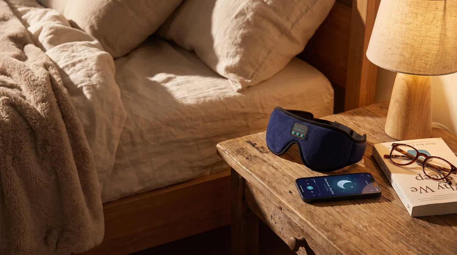 Hushova mask beside a phone showing the calm sleep-sound app