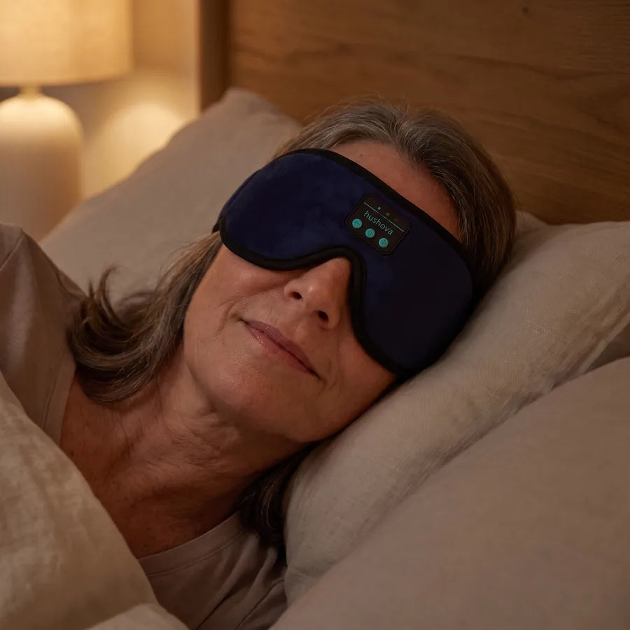 Woman resting while wearing the navy Hushova sleep mask